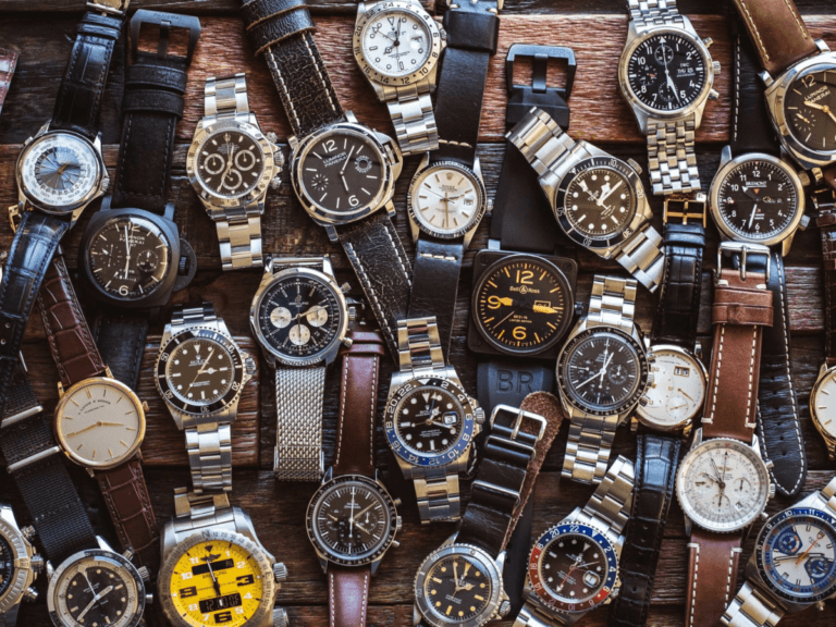 Top 10 First Watches to Kickstart Your Collection for Men 1 A large variety of watches are elegantly placed on a wooden table, emphasising their intricate designs and styles.